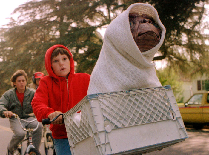 Il piccolo Elliott (Henry Thomas) e l’alieno E.T. scappano in sella alla bici dalle grinfie della NASA nella favola sci-fi di Steven Spielberg (1982)