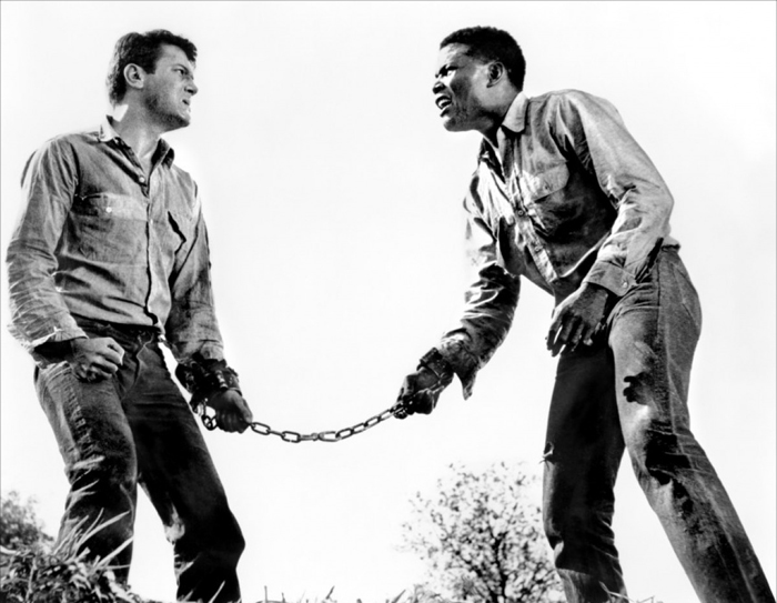  Il razzista Tony Curtis e l’afro Sidney Poitier sono detenuti in fuga, incatenati l’uno all’altro, ne La Parete di Fango (1958) 