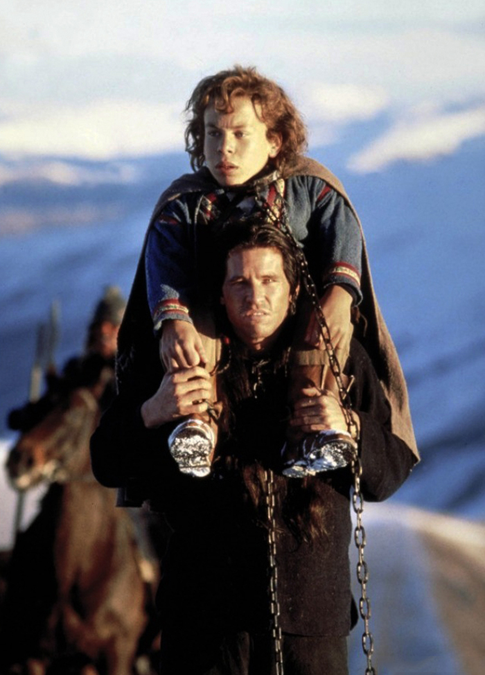 L’aspirante stregone Willow (Warwick Davis) e il ladruncolo spadaccino Madmartigan (Val Kilmer) se la danno a gambe dall’esercito della fattucchiera Bavmorda, nel fantasy di Ron Howard (1988)